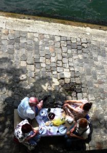 A beautiful day beckoned these people to pack a picnic lunch and enjoy a peaceful outing along the Seine River.